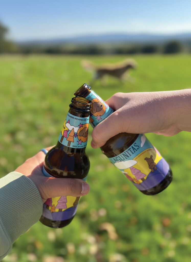 Two people giving an outdoor toast with lagunitas