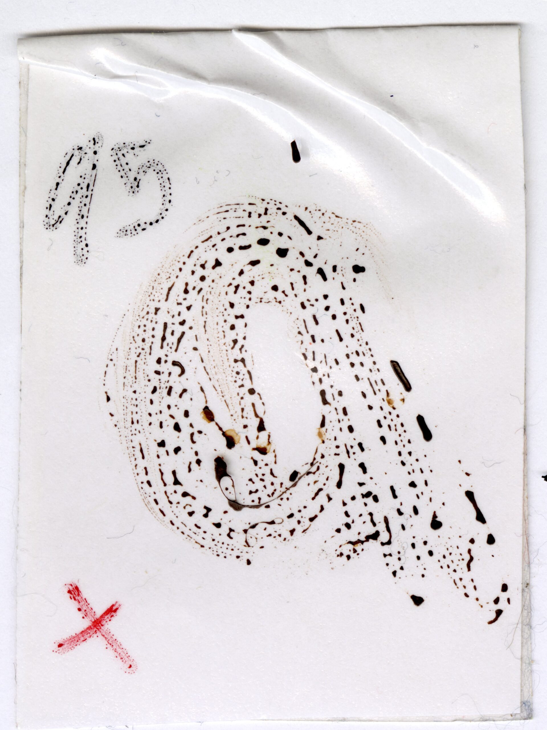 white piece of tape with an 'a' drawn in watercolor.