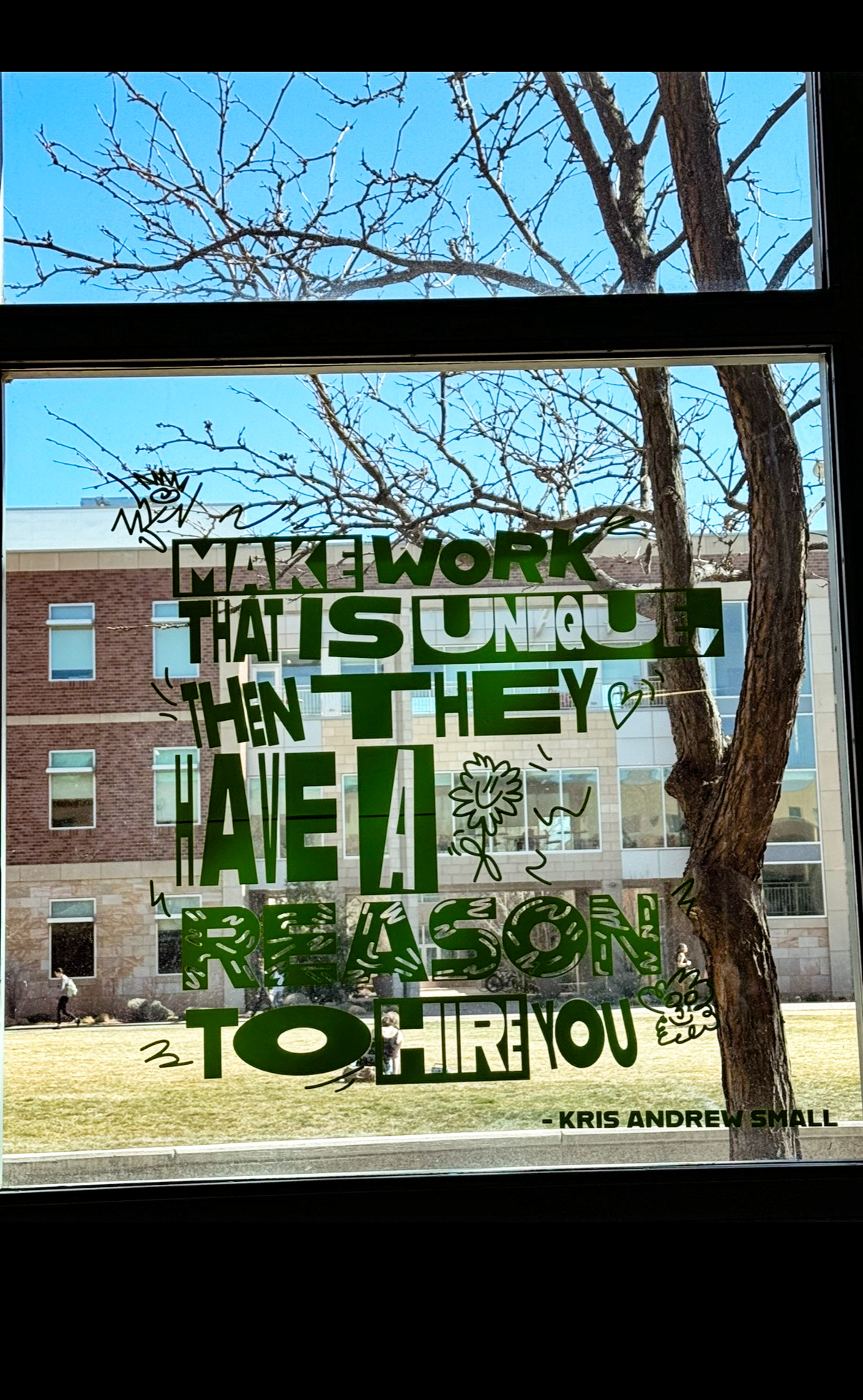 window with vinyl of a Kris Andrew Small quote.